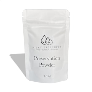 Może przedstawiać: Biała saszetka z czarnym logo, na kt&oacute;rym widnieje napis "Milky Treasures Make Yourself a Memory". Saszetka zawiera biały proszek z etykietą "Preservation Powder 1.5 oz."
