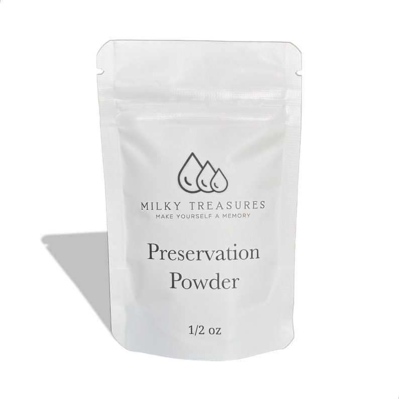Może przedstawiać: Biała saszetka z czarnym logo, na kt&oacute;rym widnieje napis "Milky Treasures Make Yourself a Memory". Saszetka zawiera biały proszek z etykietą "Preservation Powder 1/2 oz."