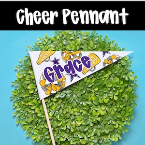 May include: A white pennant with the name "Grace" in purple script, decorated with yellow and gray cheerleading elements. The pennant is on a wooden stick, set against a backdrop of green foliage and a blue background. The text "Cheer Pennant" is at the top.