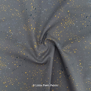 May include: Gray fabric with a speckled pattern of yellow, navy, and white dots. The fabric is slightly wrinkled, with the text "Little Fawn Fabric" in the bottom right corner.