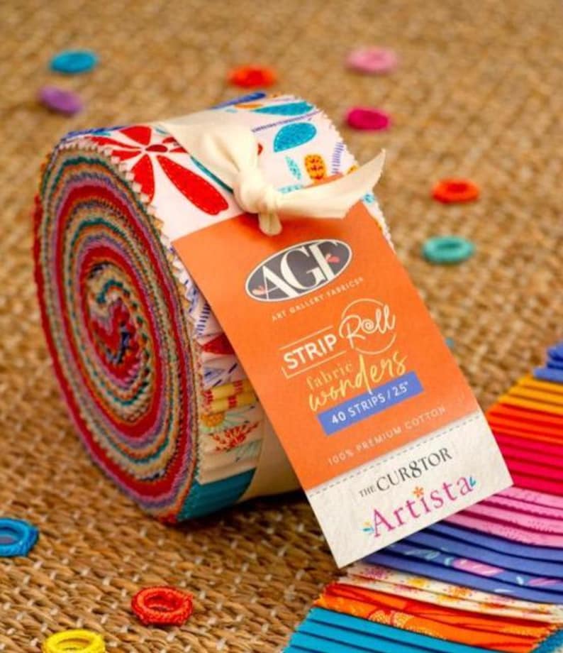 May include: A rolled bundle of fabric strips with a colorful, patterned design. The roll is tied with a cream-colored ribbon and features a tag that reads "Strip Roll Wonders" and "40 Strips/2.5"" with the brand name "Art Gallery Fabrics". The fabric is 100% premium cotton.