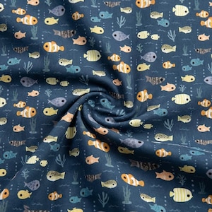 May include: Dark blue fabric with a repeating pattern of colorful cartoon fish, seaweed, and bubbles. The fish are in shades of orange, yellow, pink, and blue. The fabric is slightly wrinkled, creating shadows and depth.