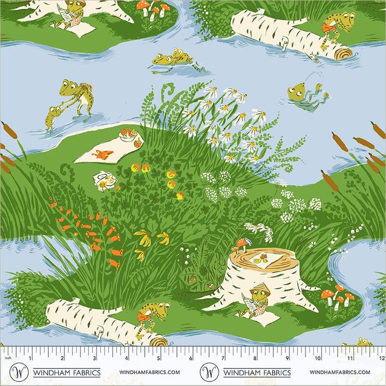 May include: A light blue fabric featuring a repeating pattern of green frogs in a natural setting with birch logs, white flowers, orange plants, and cattails. A white ruler at the bottom shows measurements in inches from 0 to 12 inches.