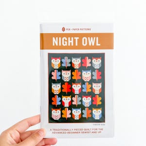 May include: A sewing pattern titled "Night Owl" featuring a colorful owl quilt design. The cover displays a grid of owl and leaf patterns in various colors, including red, orange, blue, and white. The text "Pen Paper Patterns" is at the top.