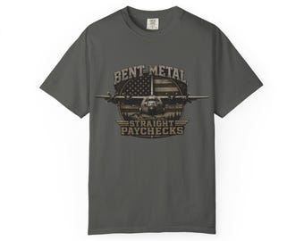 Puede incluir: Camiseta gris oscuro con el texto "BENT METAL STRAIGHT PAYCHECKS". El diseño incluye una bandera estadounidense, un avión y una silueta de bosque.
