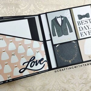 May include: A black scrapbook with a pink and white patterned page featuring a white dress design. The scrapbook has a black page with the word "Love" in white lettering. The other pages have a black background with white text that says "Groom" and "Bride". One page has a black bow tie and the text "Best Day Ever".