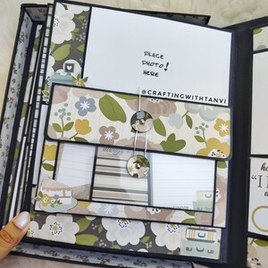 May include: A black scrapbook with a floral design and a white card that says "Place Photo! Here" and "@CraftingWithTanvi".