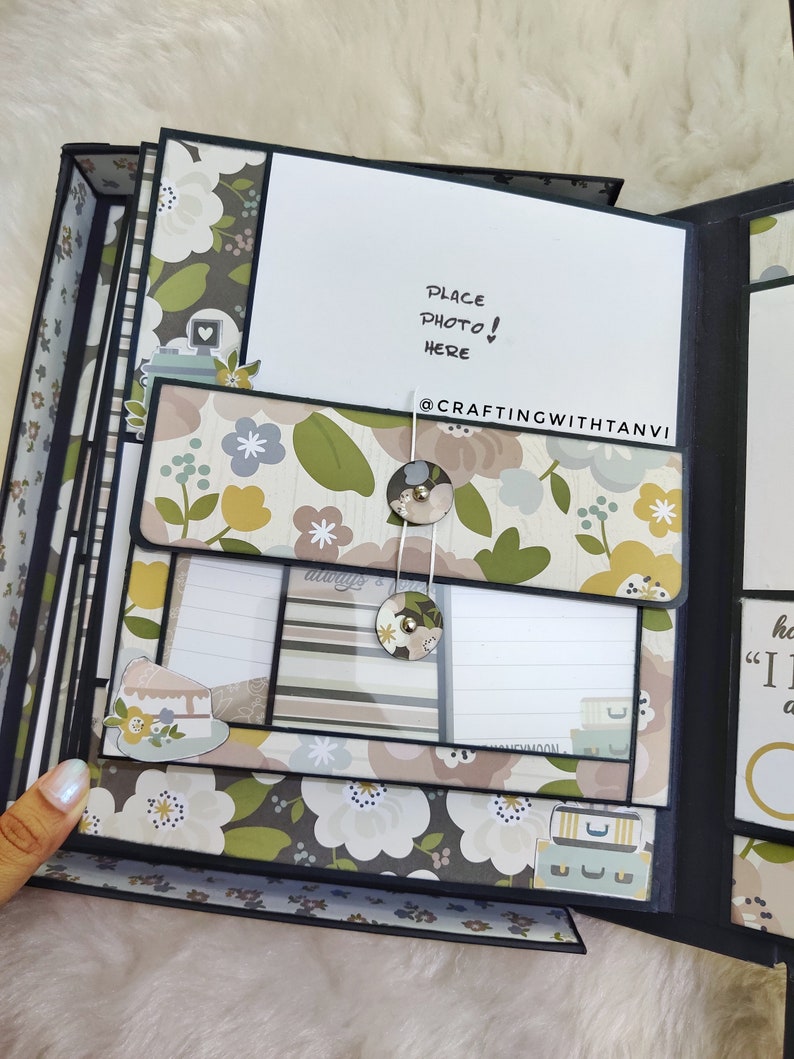 May include: A black scrapbook with a floral design and a white card that says "Place Photo! Here" and "@CraftingWithTanvi".