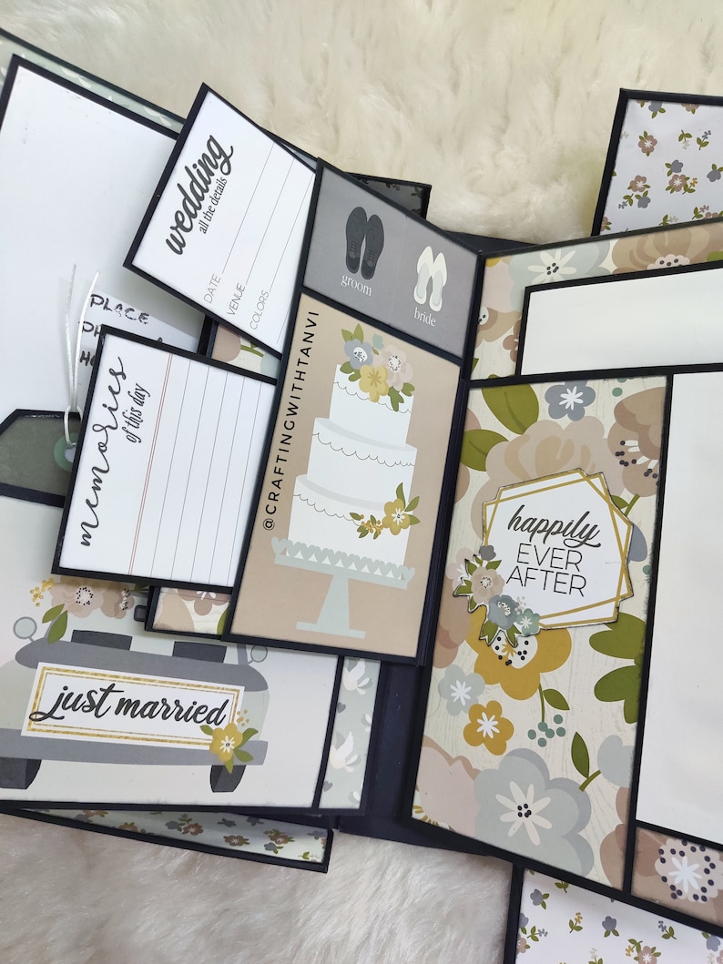 May include: A wedding scrapbook featuring a floral design and the text "happily ever after". The scrapbook has several pages with different designs, including a wedding cake, a car with the text "just married", and a page with the text "wedding all the details".