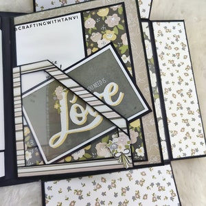 May include: A multi-layered scrapbook with a floral pattern and the word "Love" in gold lettering. The scrapbook is decorated with a floral bouquet and the text "You need is".