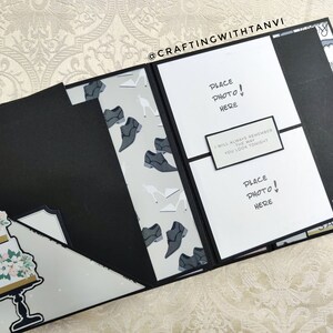 May include: A black scrapbook with white pages and a white card that says "Place Photo! Here" and "I will always remember the way you look tonight". The scrapbook has a white and gray patterned paper with images of shoes and a white cake with flowers.
