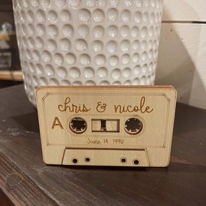 May include: A wooden cassette tape with the text "chris & nicole" and "June 14, 1998" engraved on it.