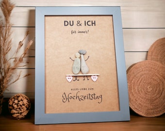 May include: A framed print with a brown background featuring a couple made of stones, with the text "DU & ICH für immer!" and "ALLES LIEBE ZUM Hochzeitstag".