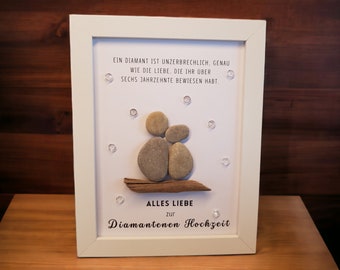 May include: A white framed picture with a stone couple, a piece of driftwood, and the text "EIN DIAMANT IST UNZERBRECHLICH, GENAU WIE DIE LIEBE, DIE IHR ÜBER SECHS JAHRZEHNTE BEWIESEN HABT. ALLES LIEBE zur Diamantenen Hochzeit".