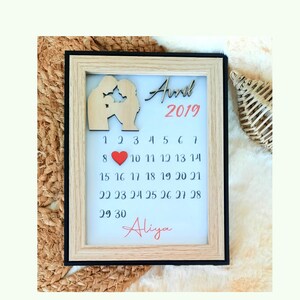 Peut inclure: Un calendrier en bois encadré avec un cœur rouge et le texte "Annul 2019" et "Aliya".