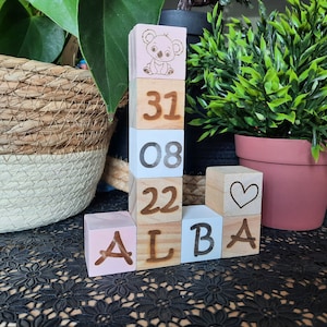 Peut inclure: Blocs en bois de couleur rose, blanche et marron. Les blocs épellent "ALBA" et comprennent les chiffres "31", "08", "22" et un symbole de cœur.