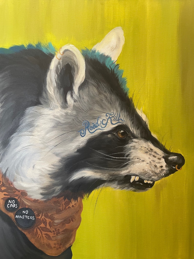 May include: A close-up portrait of a raccoon with a blue and green mohawk, a gold nose ring, and a brown bandana with the words "No Cars, No Masters" on two buttons. The raccoon has a tattoo that says "Road Kill" on its face. The background is a bright yellow.
