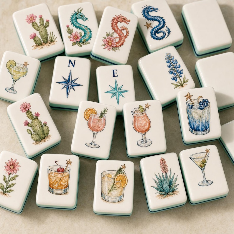 May include: A collection of rectangular mahjong tiles featuring colorful illustrations of cocktails, cacti, flowers, dragons, and compass directions labeled with N and E. Each white tile has a smooth finish and displays detailed artwork of drinks with garnishes, desert plants, and mythical creatures.