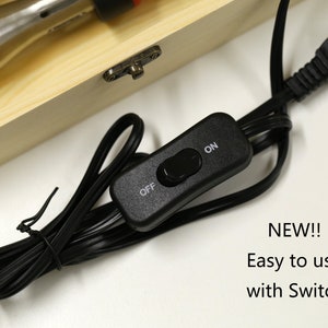 May include: A black electrical cord with a plug and an on/off switch. The cord is coiled and the switch is labeled "ON" and "OFF".