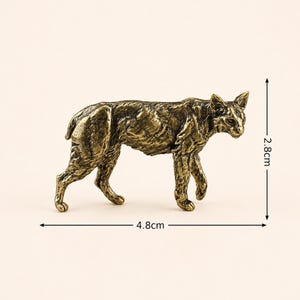 May include: A bronze-toned metal figurine of a bobcat in a walking pose. The sculpture features detailed fur texture and pointed ears. Dimension lines indicate a height of 2.8 cm and a length of 4.8 cm, providing a clear scale for the small animal statue.