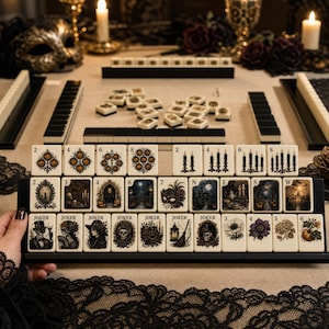 May include: A set of cream-colored mahjong tiles featuring intricate illustrations of pumpkins, candles, skulls, masks, and floral motifs. The tiles are arranged in rows on black racks, with some tiles displaying numbers 2 through 8, letters N, E, S, W, and the word JOKER.