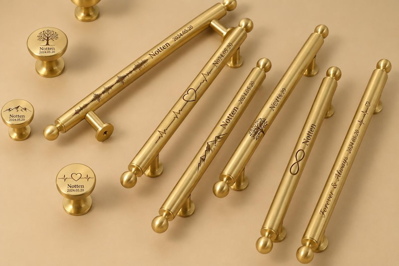 May include: Gold-toned cabinet hardware set featuring various handle styles and matching knobs. The handles are engraved with designs like a mountain range, heartbeat, tree, and infinity symbol, along with the name "Notten" and dates.