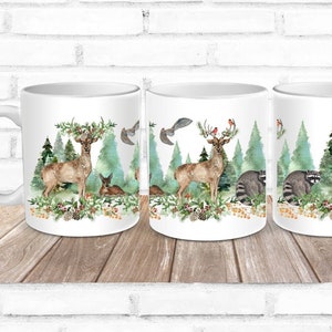 May include: Three white ceramic mugs with a winter forest scene printed on them. The scene features a deer, raccoons, a fox, birds, and pine trees. The mugs are perfect for hot beverages.