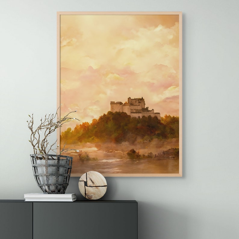 May include: A framed watercolor painting of a castle on a hilltop with a misty river in the foreground. The sky is a soft orange and pink.