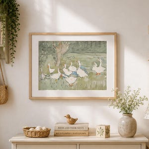 May include: A cozy nursery scene with a framed watercolor painting of geese, a woven basket, and a plush bunny. A light-colored dresser, a lamp, and a small shelf with a teddy bear and books complete the room's decor.