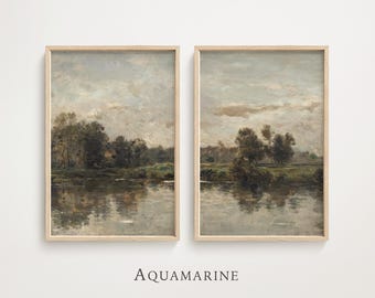 May include: Two framed landscape paintings with a serene river scene. The artwork features muted tones of gray, brown, and green, with reflections in the water. The frames are a light wood color. The word "AQUAMARINE" is printed below the paintings.