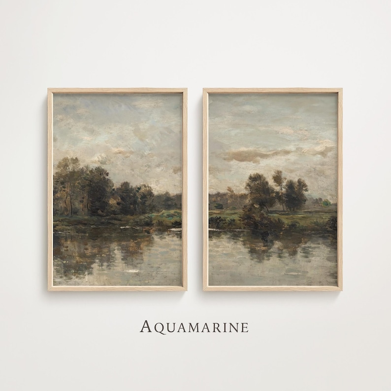 May include: Two framed landscape paintings with a serene river scene. The artwork features muted tones of gray, brown, and green, with reflections in the water. The frames are a light wood color. The word "AQUAMARINE" is printed below the paintings.