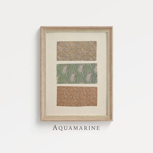 Puede incluir: Lámina artística enmarcada con tres paneles rectangulares que muestran patrones botánicos en oro, verde y marrón. La palabra "AQUAMARINE" está impresa debajo en una fuente serif. El marco es de color madera clara. Ideal para el hogar.