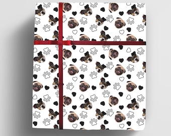 May include: White wrapping paper with a repeating pattern of black paw prints, hearts, and dog faces. The dog faces are a mix of pugs and Jack Russell terriers.