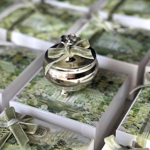 Silberfarbene Geschenkbox, runder Bonbonbehälter aus Metall mit Blumendeckel und Samtband