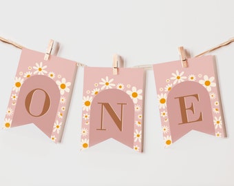 May include: A pink and white banner with the word "ONE" in brown letters. The banner is decorated with white daisies with yellow centers. Each letter is on a separate flag.