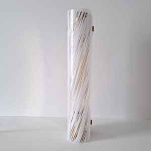 May include: A white cylindrical glass lampshade with a swirling pattern. The lampshade is mounted on a wall with two brass brackets.