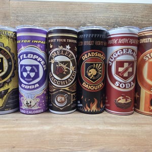 Peut inclure: Six gobelets en acier inoxydable avec divers motifs et textes. Les gobelets présentent des graphiques et des textes tels que "Pick Eat Clean", "Flopper Soda", "Melee Macchiato", "Deadshot Daiquiri", "Juggernog Soda" et "Stamin-Up Soda".