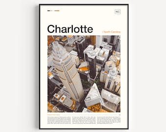 Könnte beinhalten: Gerahmtes Poster mit einer Luftaufnahme von Charlotte, North Carolina. Das Poster zeigt den Stadtnamen in großem schwarzen Text mit "/ North Carolina" darunter. Das Bild zeigt eine Stadtlandschaft mit hohen Gebäuden und einem markanten Wolkenkratzer.