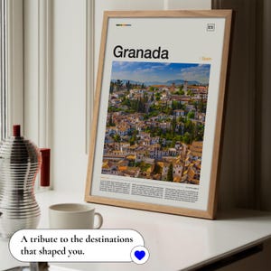May include: A framed print featuring the word "Granada" above a scenic view of the city in Spain. The print is in a light wood frame and includes the text "A tribute to the destinations that shaped you."
