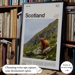 May include: A framed print featuring the word "Scotland" with an image of a Highland cow on a hillside. The print includes text indicating the United Kingdom and a small logo. The print is displayed in a room with bookshelves.