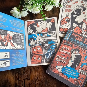 May include: Comic book-style wedding invitations with a retro aesthetic. The design features bold colors, speech bubbles, and illustrations of robots and couples. The text includes the names "Lisa Jones" and "Mark Smith."