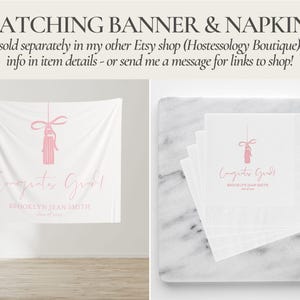 May include: White banner and napkins with pink text and a tassel design. The banner reads "Congrats Grad" with a name and "Class of 2023". Napkins are stacked on a marble surface.