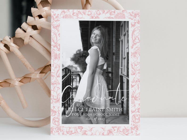 May include: A graduation announcement featuring a black and white photo of a person in a white dress. The photo is framed with a pink floral border. The word "Graduate" is written in script, along with the graduate's name, high school name, and class year.