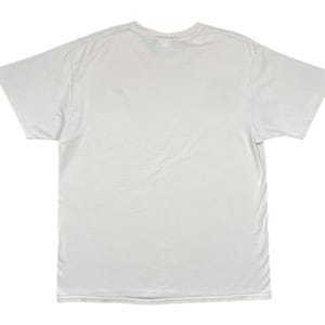 May include: A plain, off-white, short-sleeved t-shirt. The shirt is made of a soft, slightly wrinkled fabric. The neckline is a classic crew neck. The sleeves are short and extend to the mid-upper arm. The shirt is laid flat on a white background.