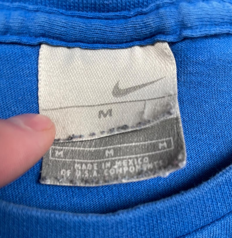 Puede incluir: Una taza de cer&aacute;mica blanca con un asa negra y el texto "But First, Coffee" en negro, en negrita. La taza est&aacute; sobre una superficie blanca.