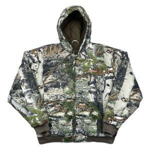 May include: A hooded camouflage jacket with a forest pattern. The jacket features a full-length zipper, a drawstring hood, and a brown ribbed hem and cuffs. The Mossy Oak logo is visible on the chest.