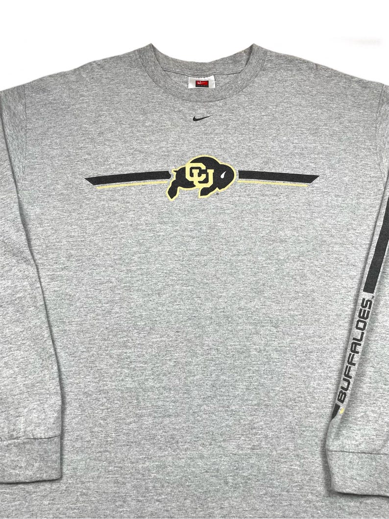 Op de afbeelding: Een witte keramische mok met een zwart handvat en de tekst "But First, Coffee" in een vetgedrukte, zwarte letter. De mok staat tegen een vage achtergrond. De mok is ongeveer 10 cm hoog.