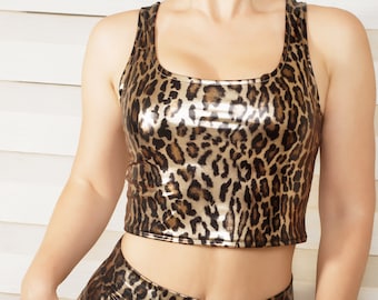 May include: A shiny gold and black leopard print crop top with a scoop neck.