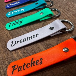 May include: Five colorful keychains with metal rings and personalized names: Charlie, Stormy, Teddy, Dreamer, and Patches. The keychains are made of a soft, flexible material.