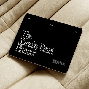 K&ouml;nnte beinhalten: Ein schwarzes Tablet-Computer mit einem wei&szlig;en Bildschirm, auf dem der Text "The Sunday Reset Planner" angezeigt wird.